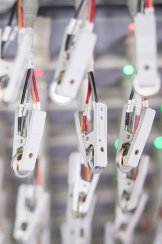 Professor Neeraj Sharma in his lab beside an array of batteries being charged