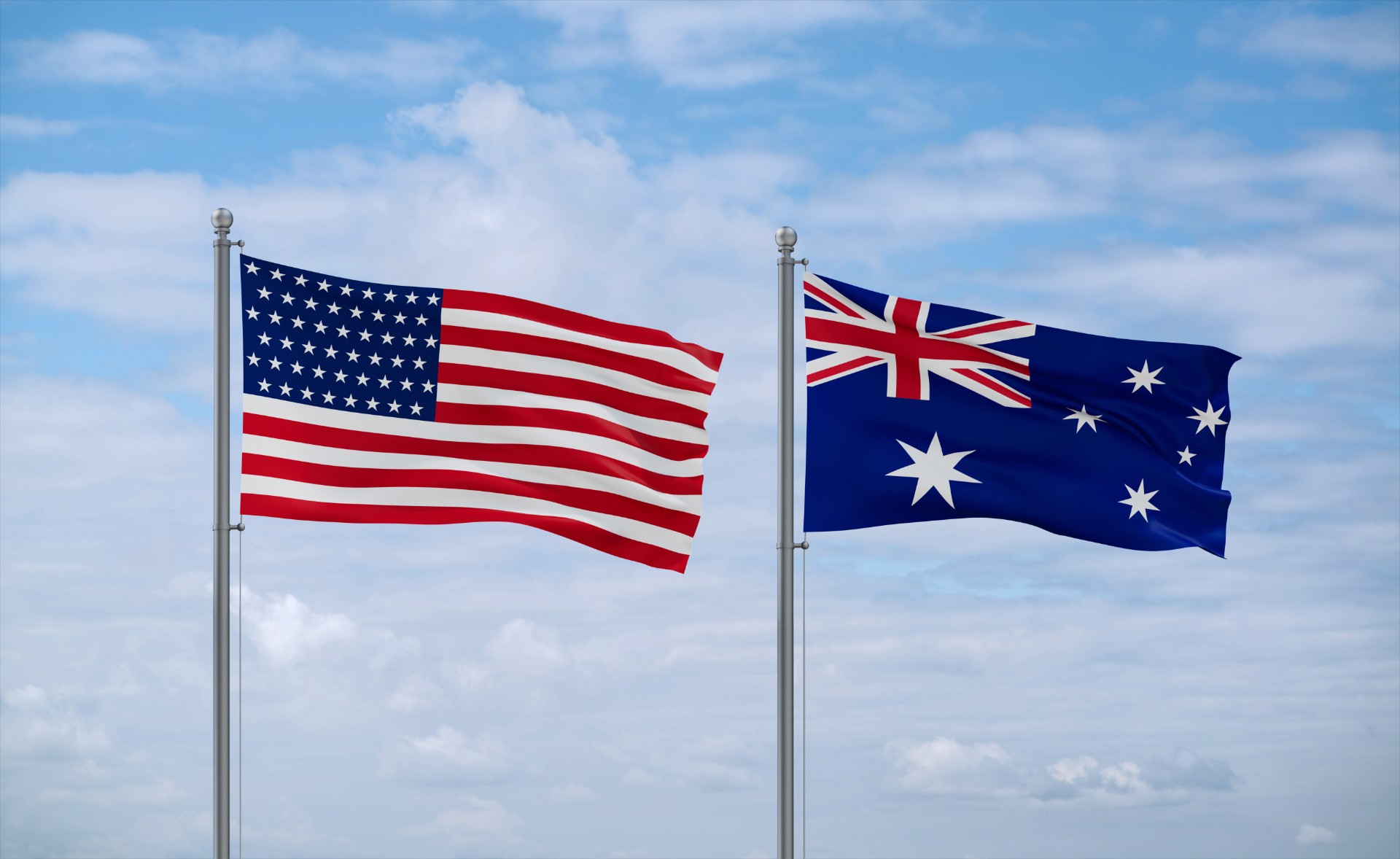 Australia and USA flags waving together on blue cloudy sky, two country relationship concept