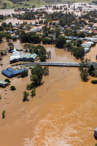 Brown floodwaters fill the streets of Lismore, submerging cars and flooding businesses