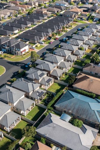 Houses beside the Georges River are engulfed by brown flood water