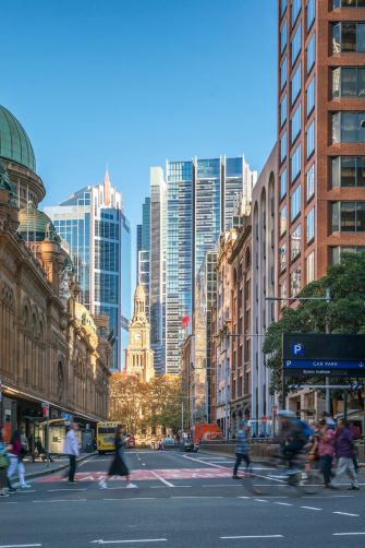 Pedestrians make their way past each other on a pavement that is also crowded with parked e-bikes.