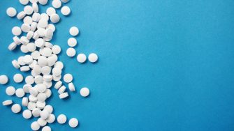 White pills on blue background stock image
