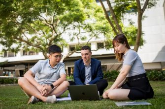 Students studying in a group on the grass
