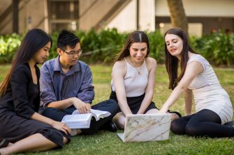 Students studying in a group on the grass