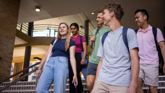 A group of students walking down the Helen Maguire Lawn steps