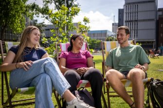 A group of students sitting on lawn chairs at the Village Green