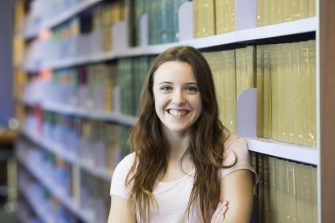 Girl standing in front of library shelves