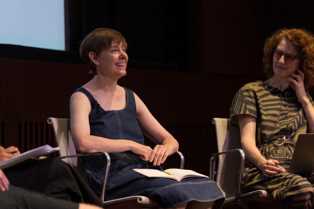 Two people in conversation on stage and smiling