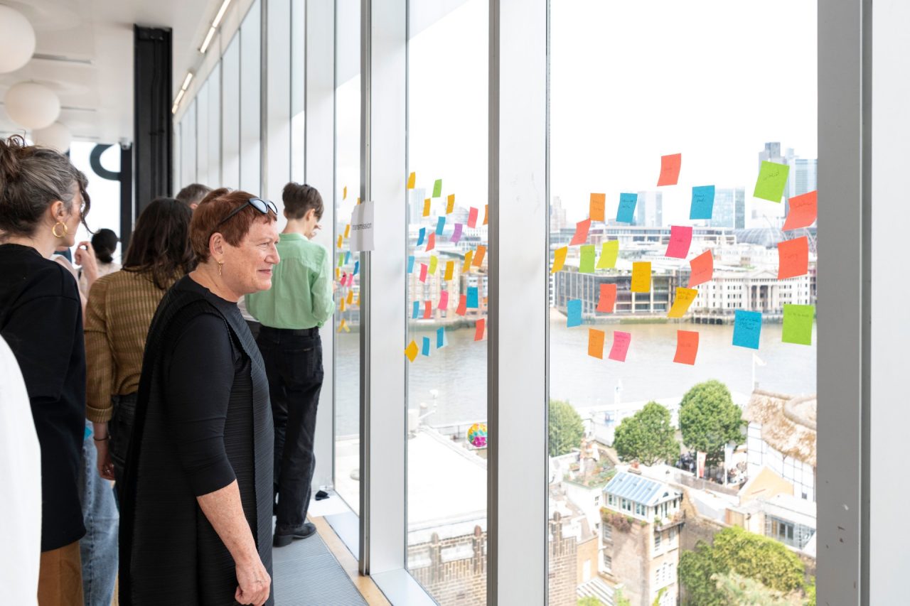 People looking at post it notes on a window