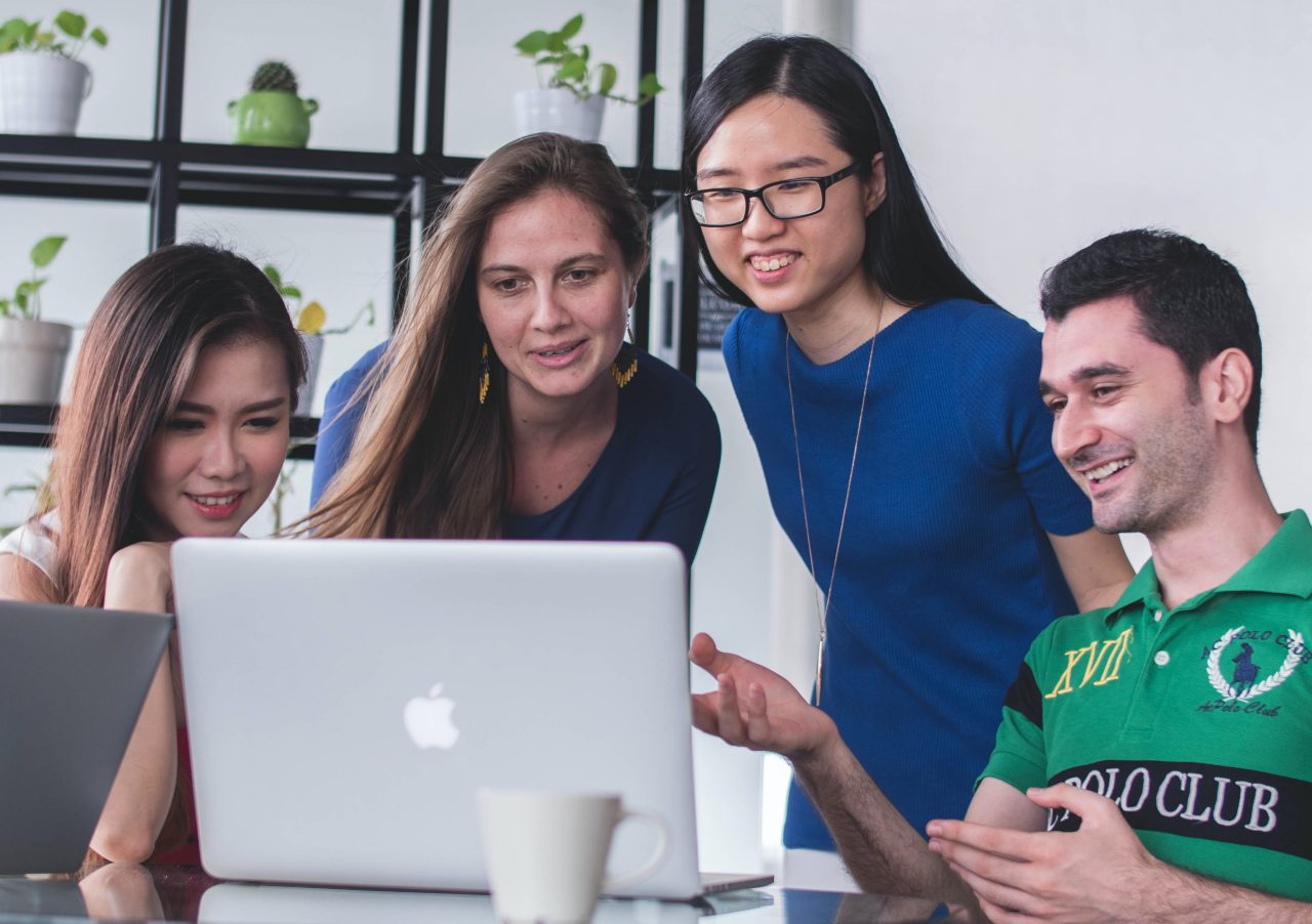 Four people looking at the laptop