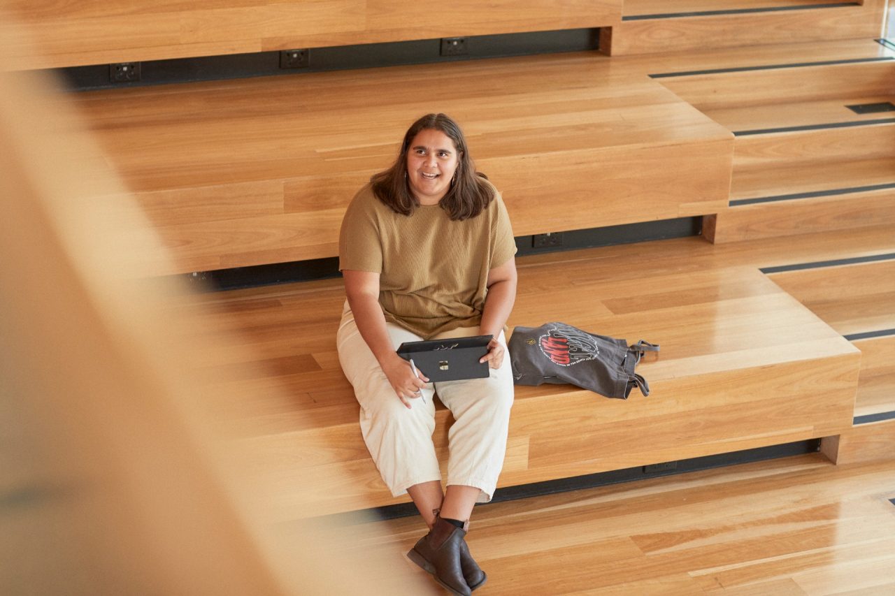 Art and design students discussing work inside the Red Center build enviroment study space.