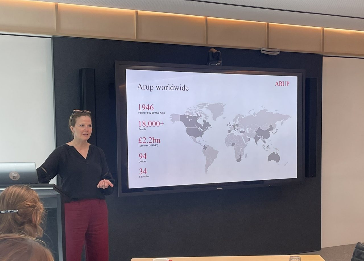 Woman standing in front of a screen giving presentation