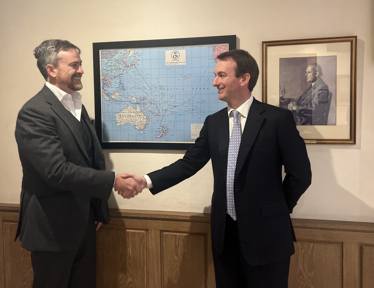 Two men in suits shaking hands.