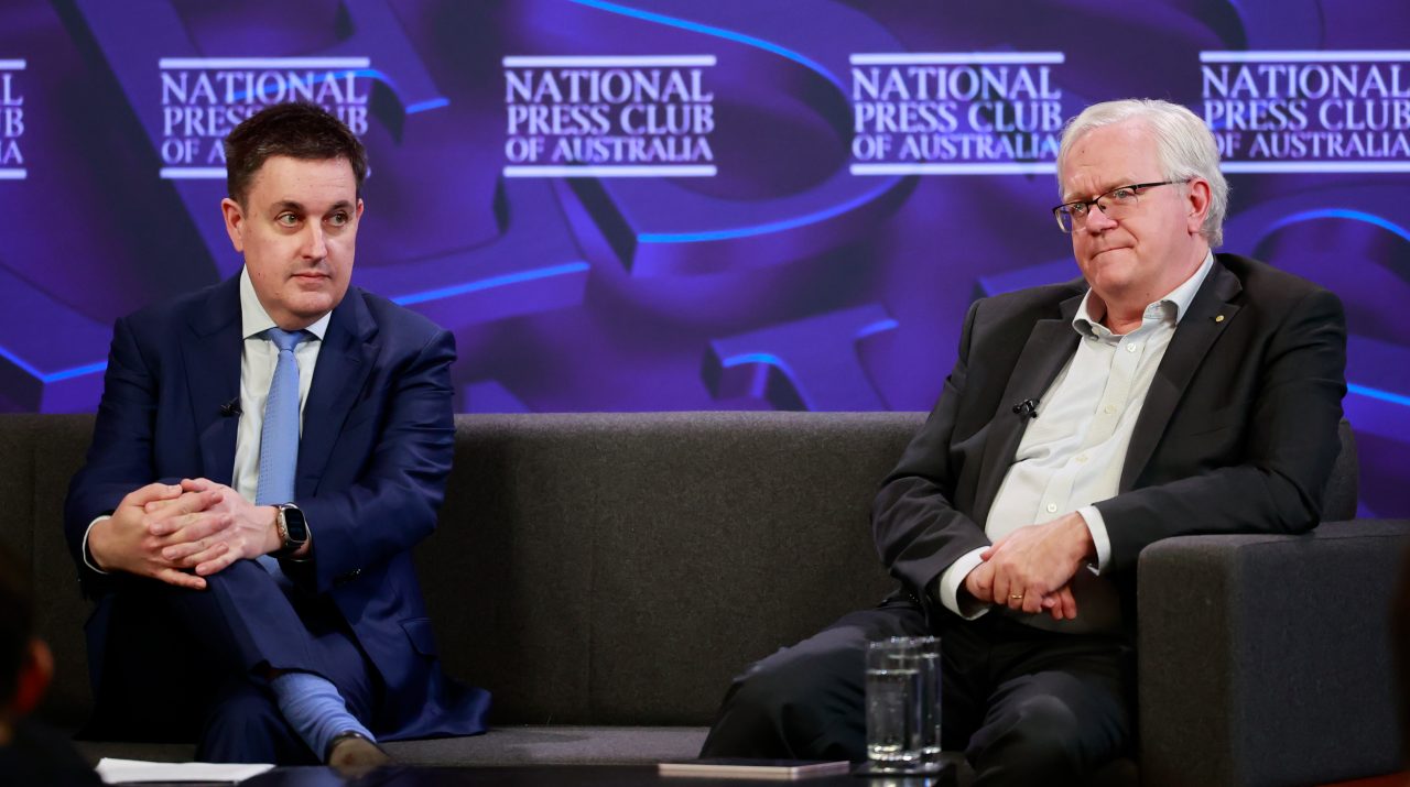 Scientia Professor Richard Holden and Professor Brian Schmidt on sit on a couch on stage at the National Press Club
