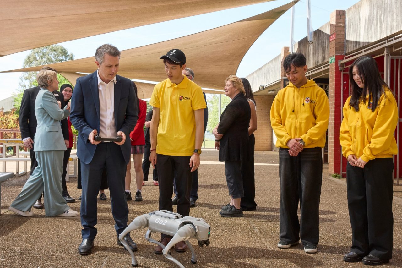 Education Minister Jason Clare controls a robot with UNSW students
